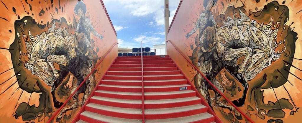 Panoramic shot looking up the red staircase toward the new Greeley Stampede mural by Cody Kuehl