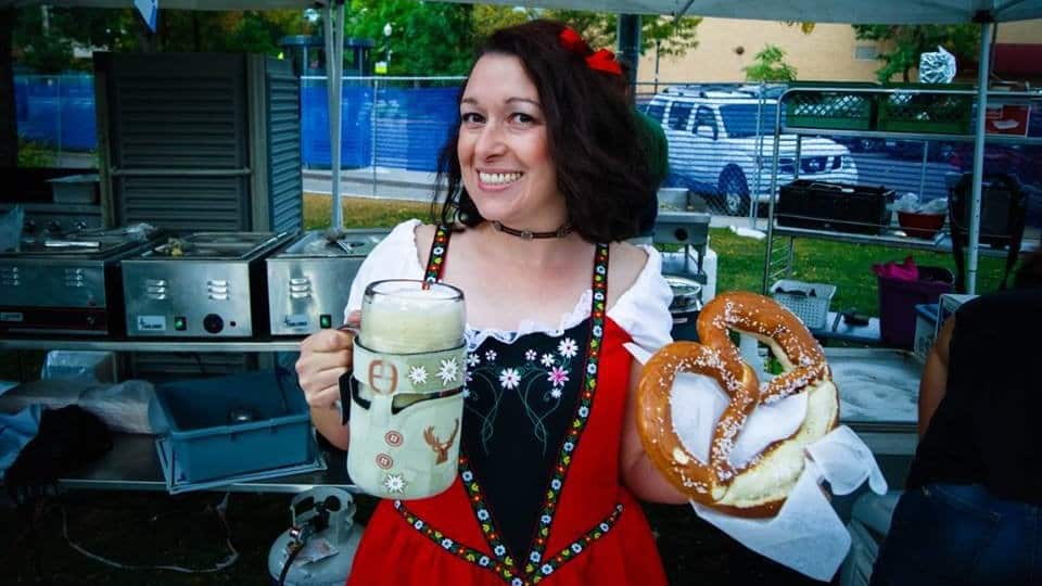 Vender holds a large soft pretzel and a foam-filled beer stein at OktoBREWfest