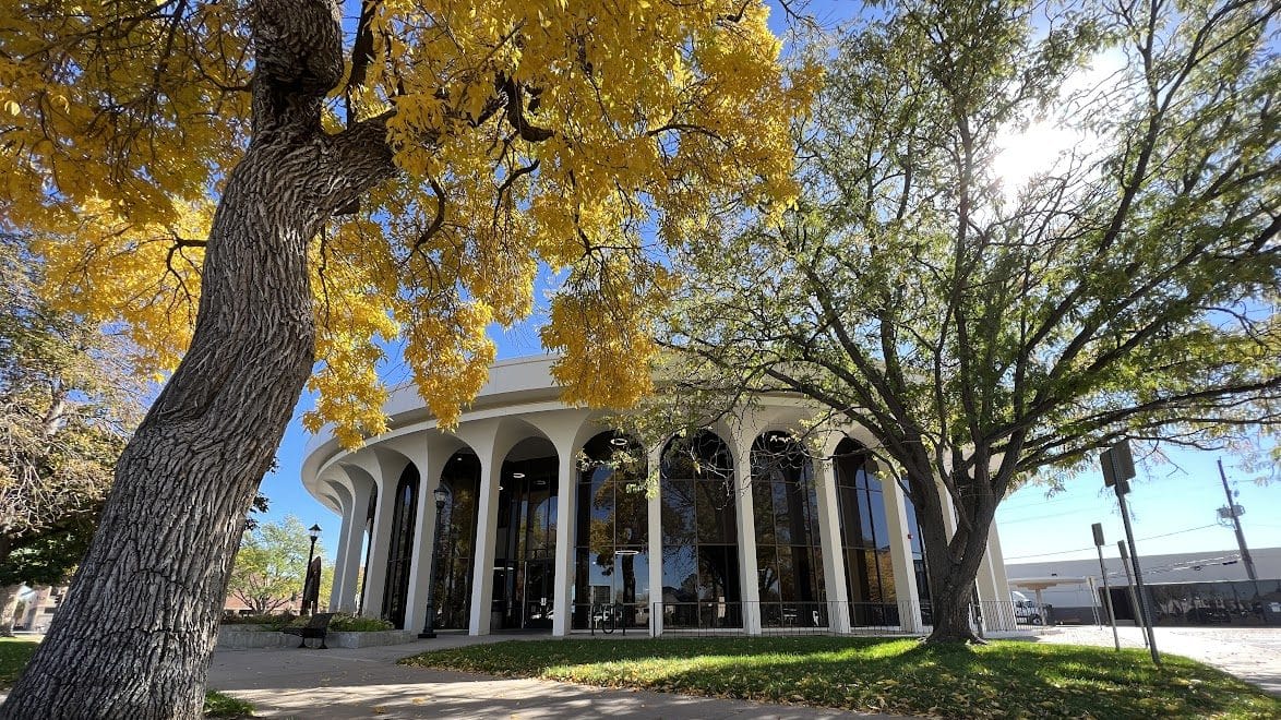 The circular, white columned City Hall in Greeley, Colorado, on a sunny fall day.